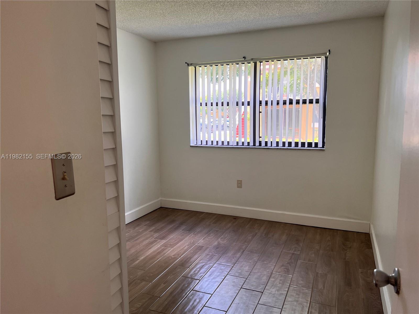 15610 Southwest 80th Street, Unit J105 Miami, FL 33193 - Photo 20 of 38 an empty room with wooden floor and windows