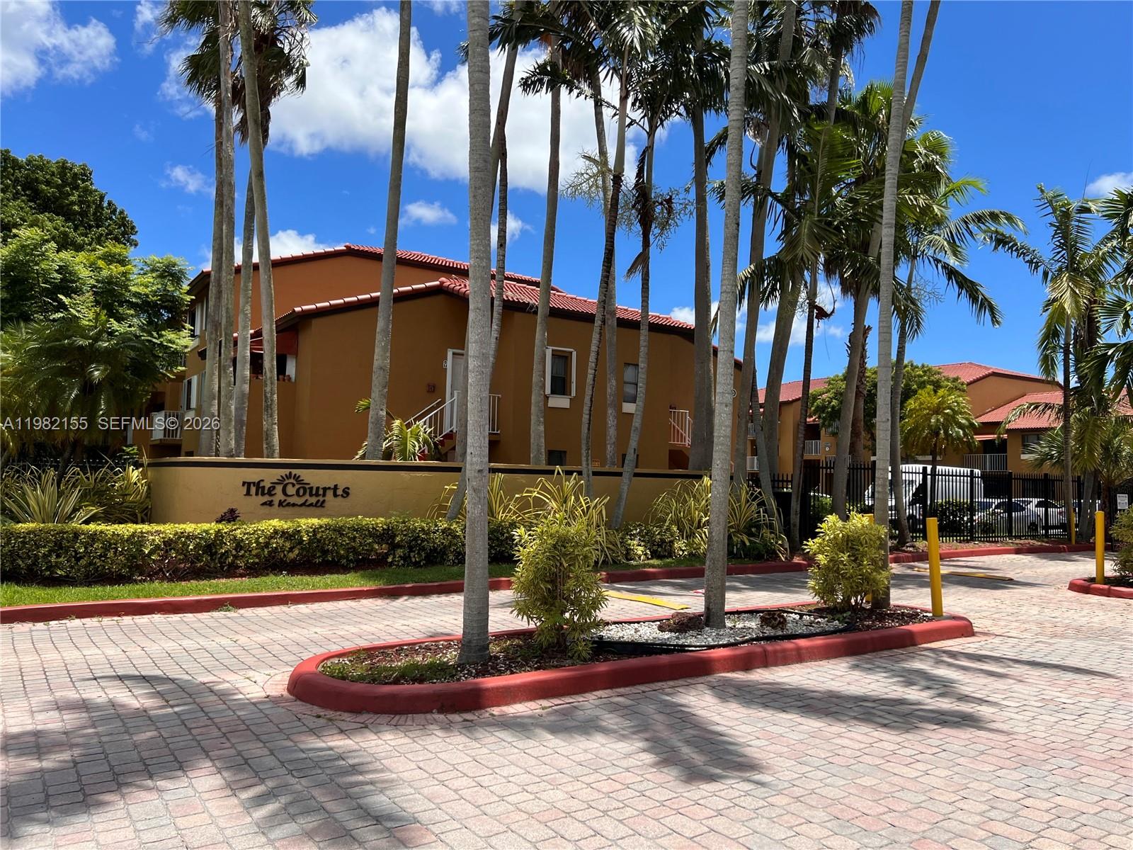 15610 Southwest 80th Street, Unit J105 Miami, FL 33193 - Photo 36 of 38 a front view of a building with palm trees