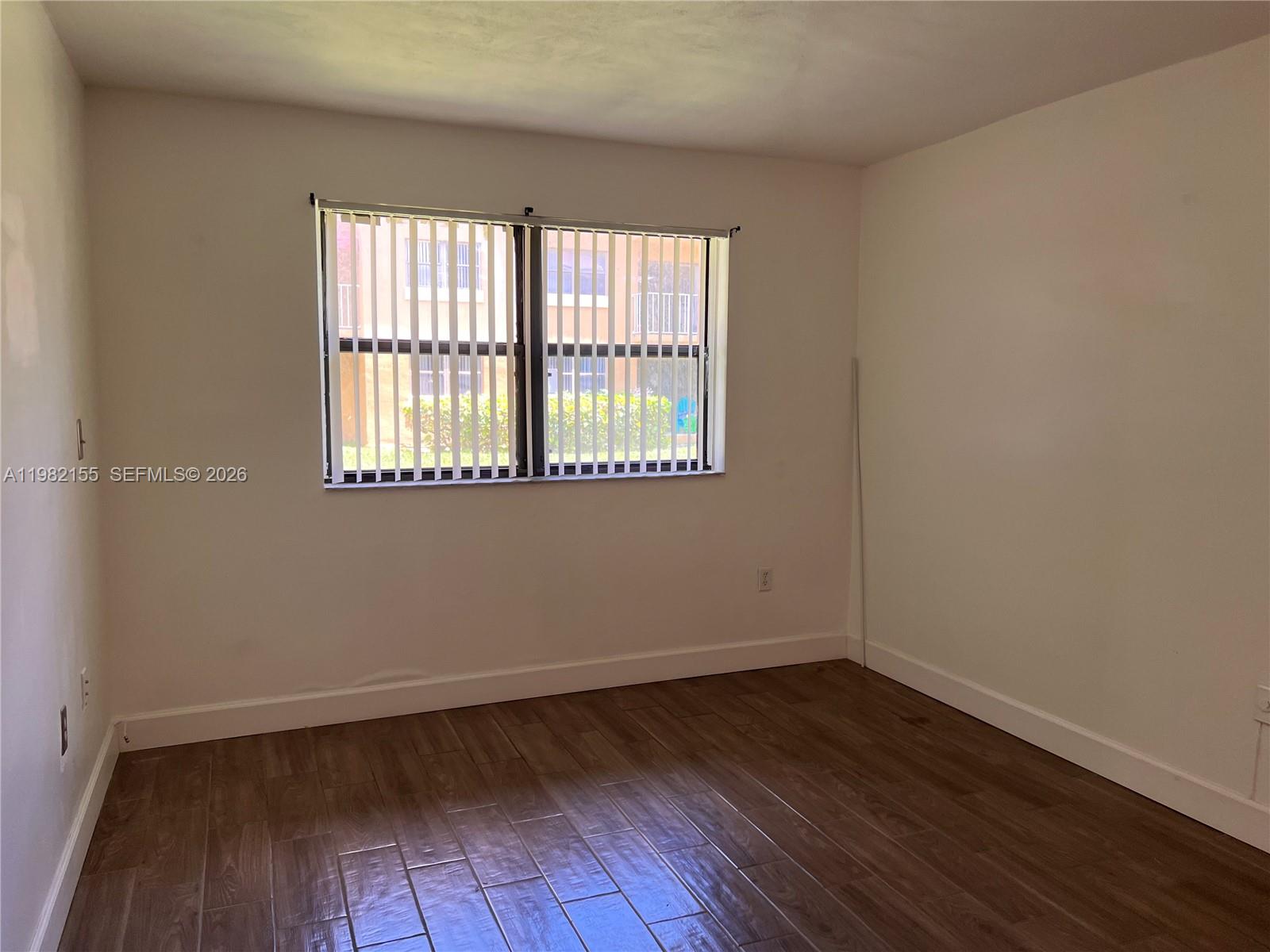 15610 Southwest 80th Street, Unit J105 Miami, FL 33193 - Photo 6 of 38 wooden floor and window in an empty room