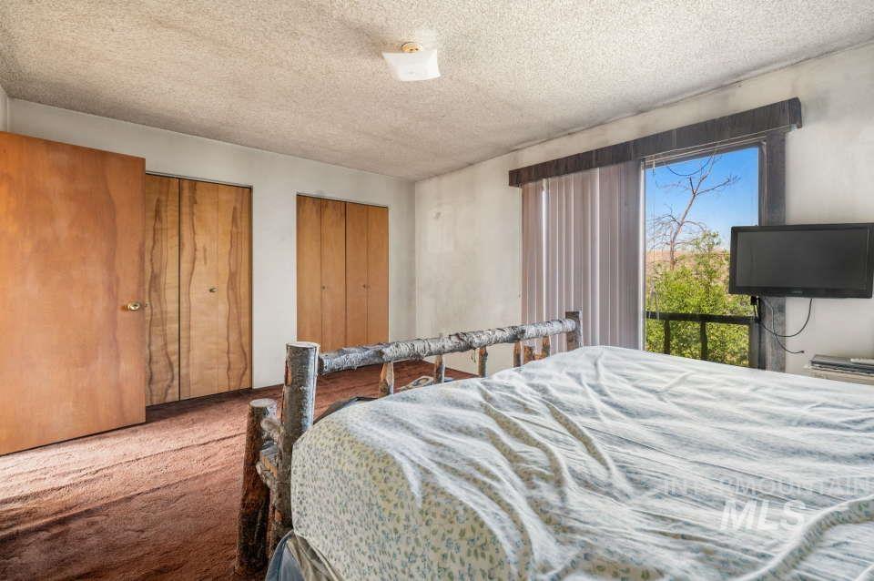 2026 Silcott Hills Road Clarkston, WA 99403 - Photo 20 of 29 Carpeted bedroom with a textured ceiling and multiple closets