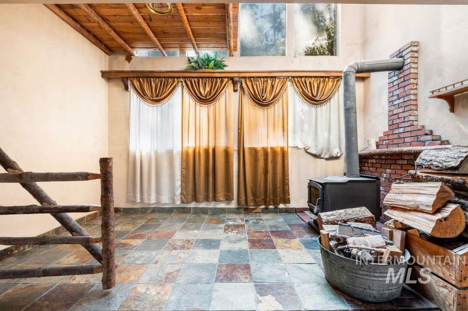 2026 Silcott Hills Road Clarkston, WA 99403 - Photo 10 of 29 Interior space with stone tile floors, wooden ceiling, and a wood stove