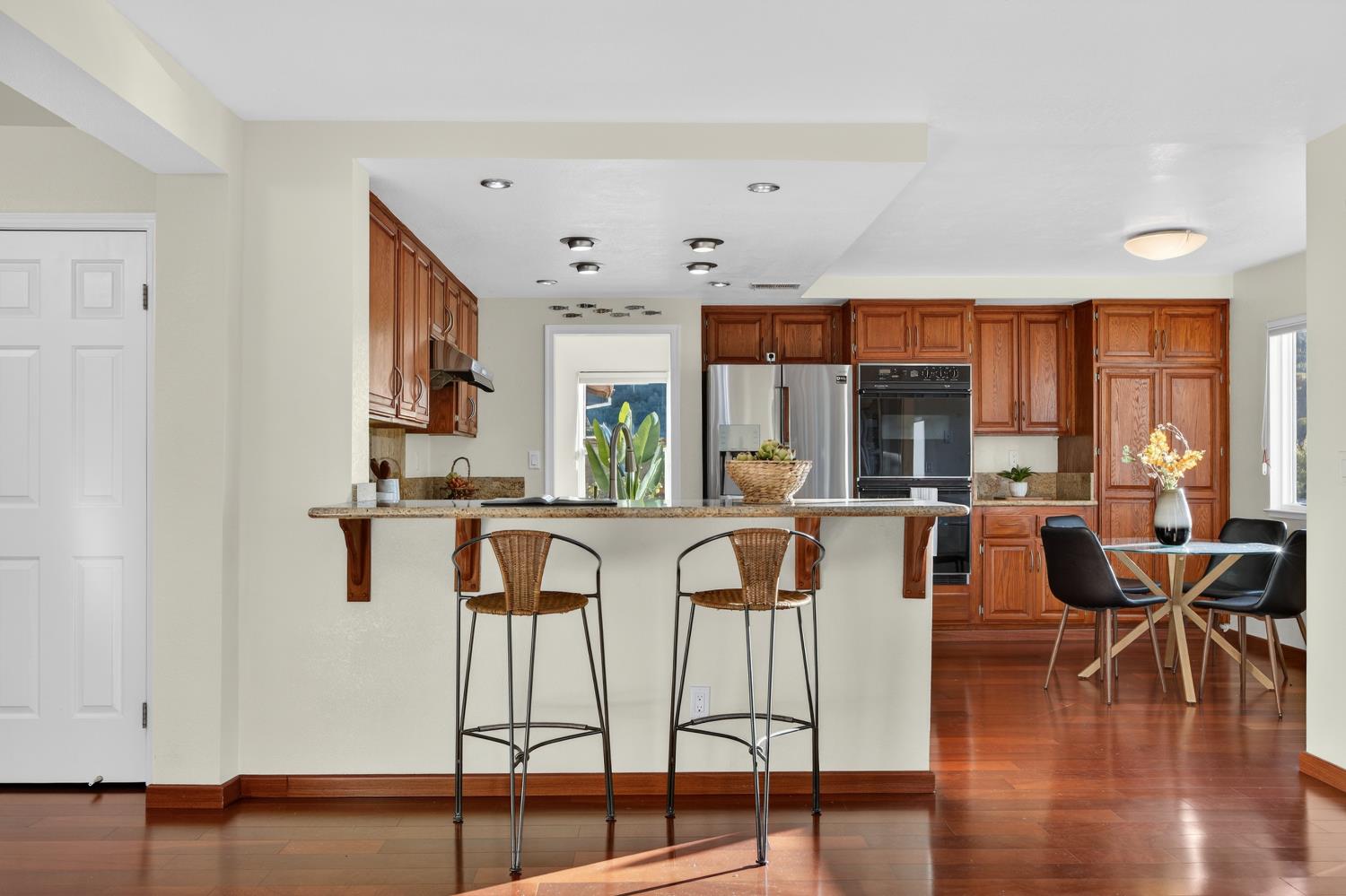 248 Carson Street Hercules, CA 94547 - Photo 20 of 70 a kitchen with stainless steel appliances granite countertop a stove top oven a sink a dining table and chairs with wooden floor