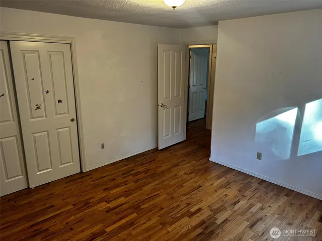 a view of an empty room with wooden floor