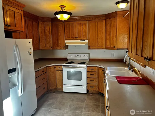 a kitchen with stainless steel appliances granite countertop a sink stove and cabinets