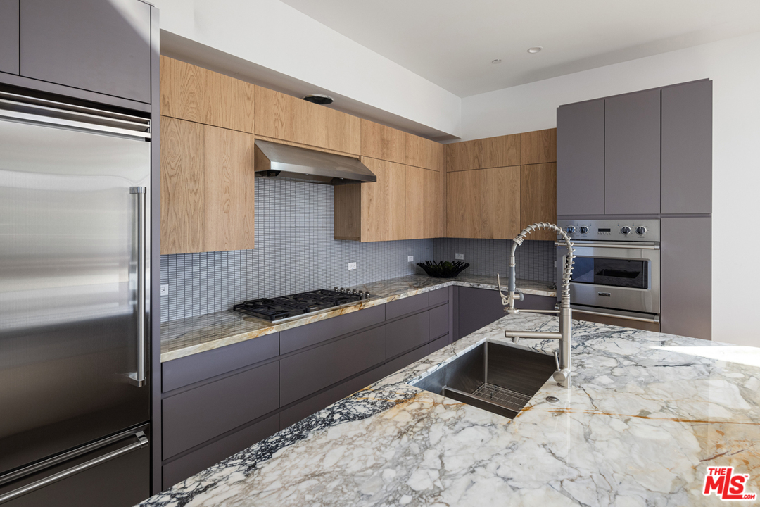 700 Brooks Avenue Venice, CA 90291 - Photo 22 of 53 a kitchen with granite countertop a stove a sink and a refrigerator