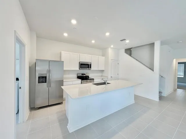 a kitchen with kitchen island white cabinets and stainless steel appliances