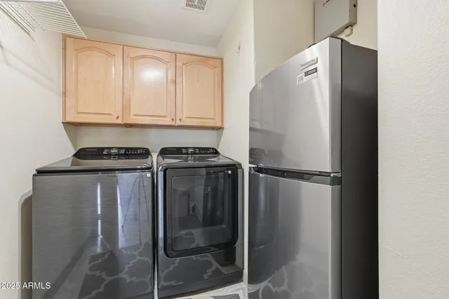 a close view of a refrigerator in kitchen and white cabinets