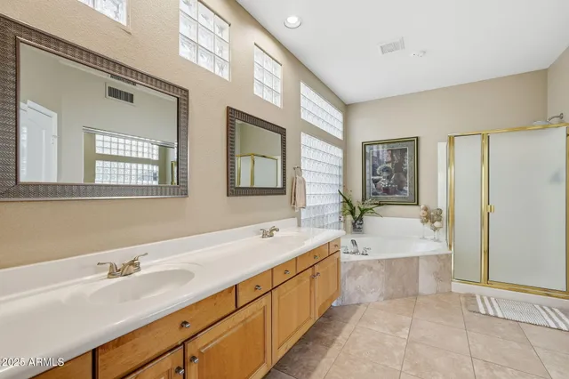 a spacious bathroom with a tub sink and mirror