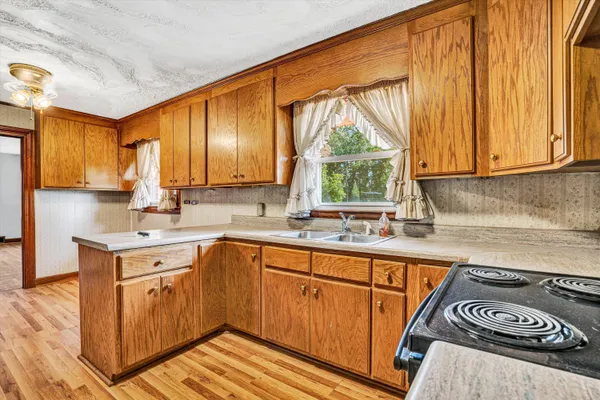 a kitchen with a sink a window and cabinets