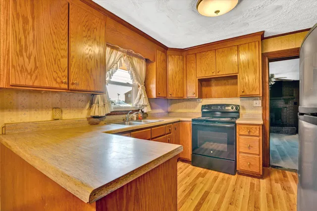 a kitchen with a refrigerator a stove top oven and a large window
