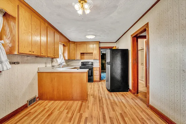 a kitchen with stainless steel appliances granite countertop a refrigerator a stove top oven a sink and dishwasher