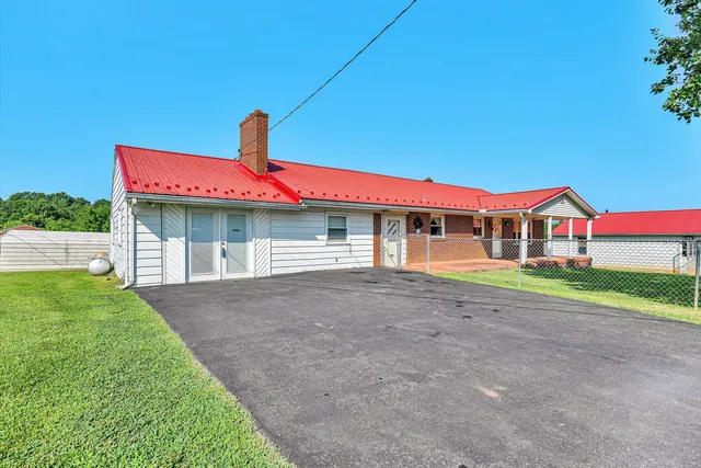 a front view of house with yard and parking