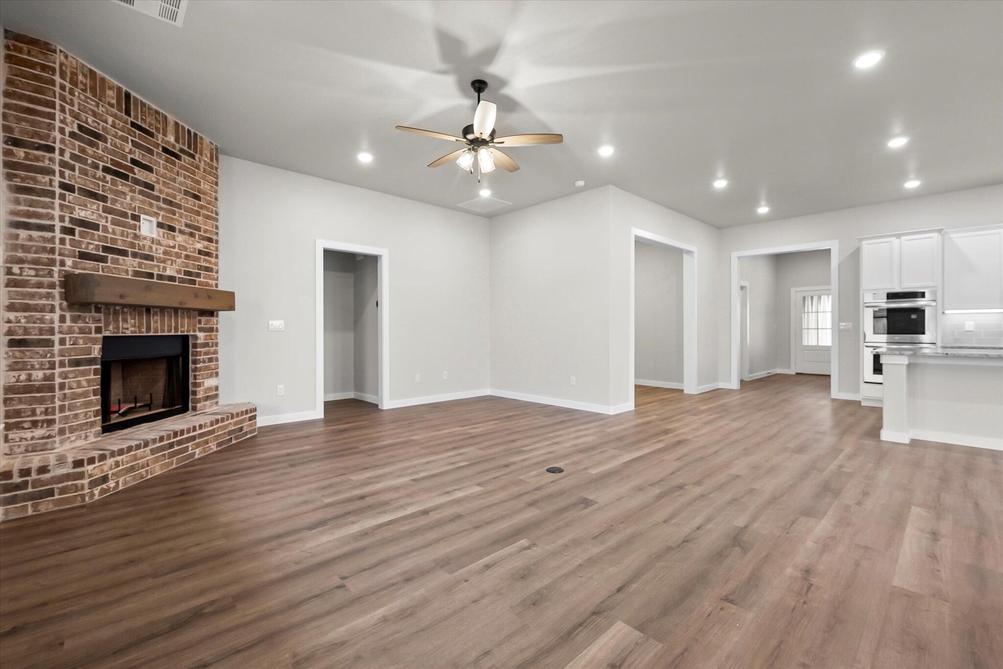 7436 30th Street Lubbock, TX 79407 - Photo 11 of 25 a view of an empty room with wooden floor a fireplace and a window