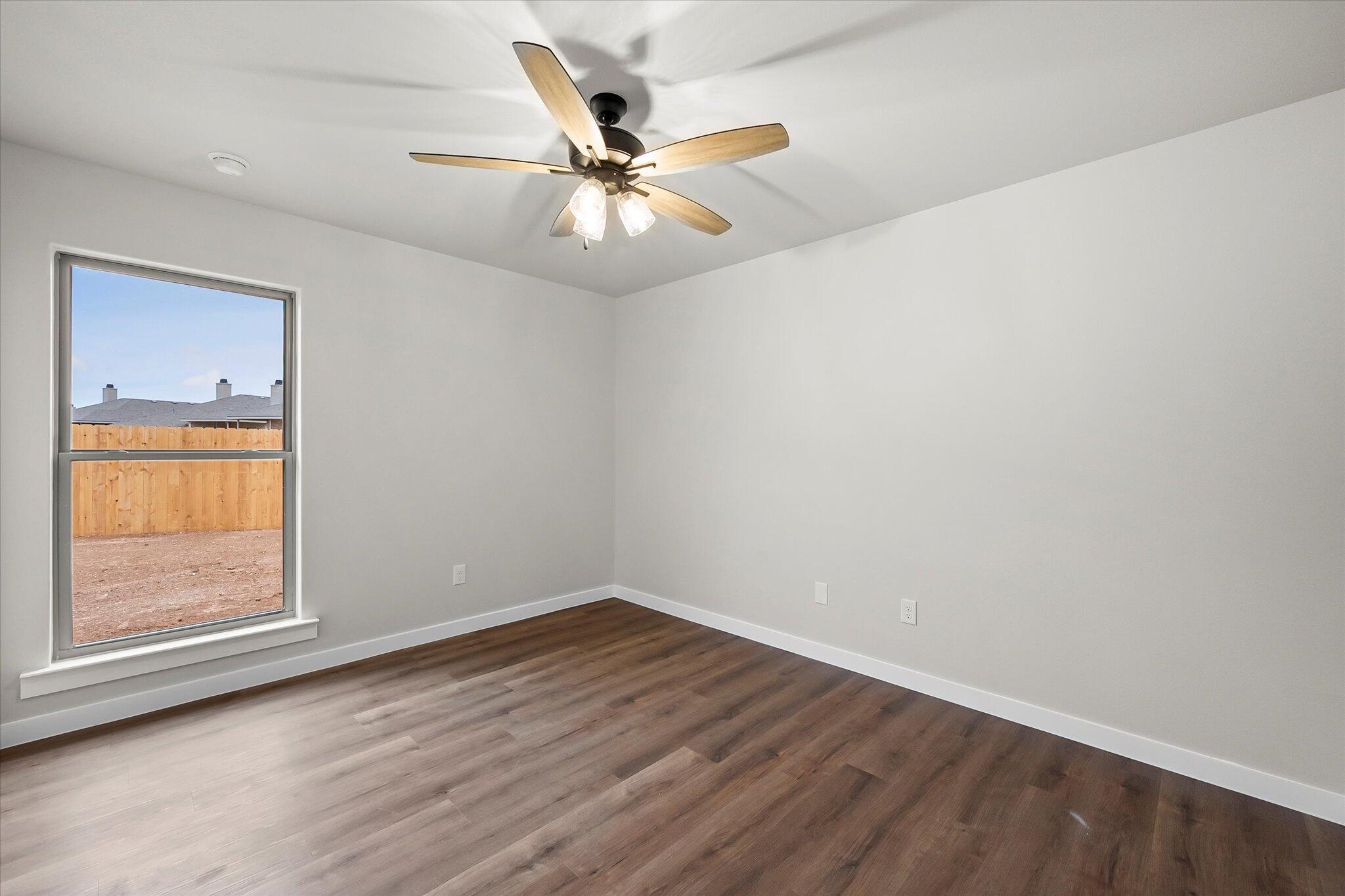 7436 30th Street Lubbock, TX 79407 - Photo 20 of 25 an empty room with a window and wooden floor