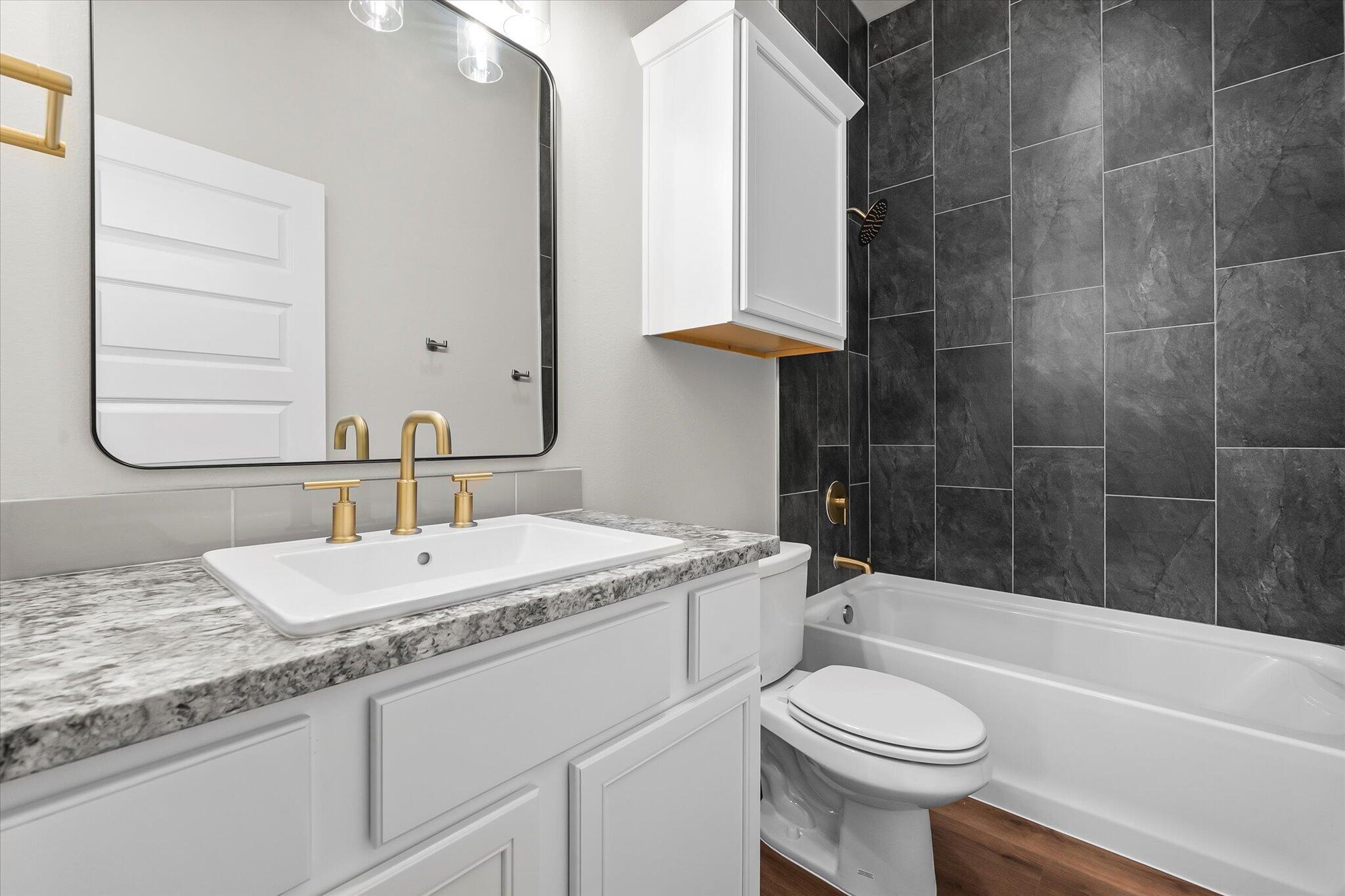 7436 30th Street Lubbock, TX 79407 - Photo 23 of 25 a bathroom with a granite countertop sink toilet and shower