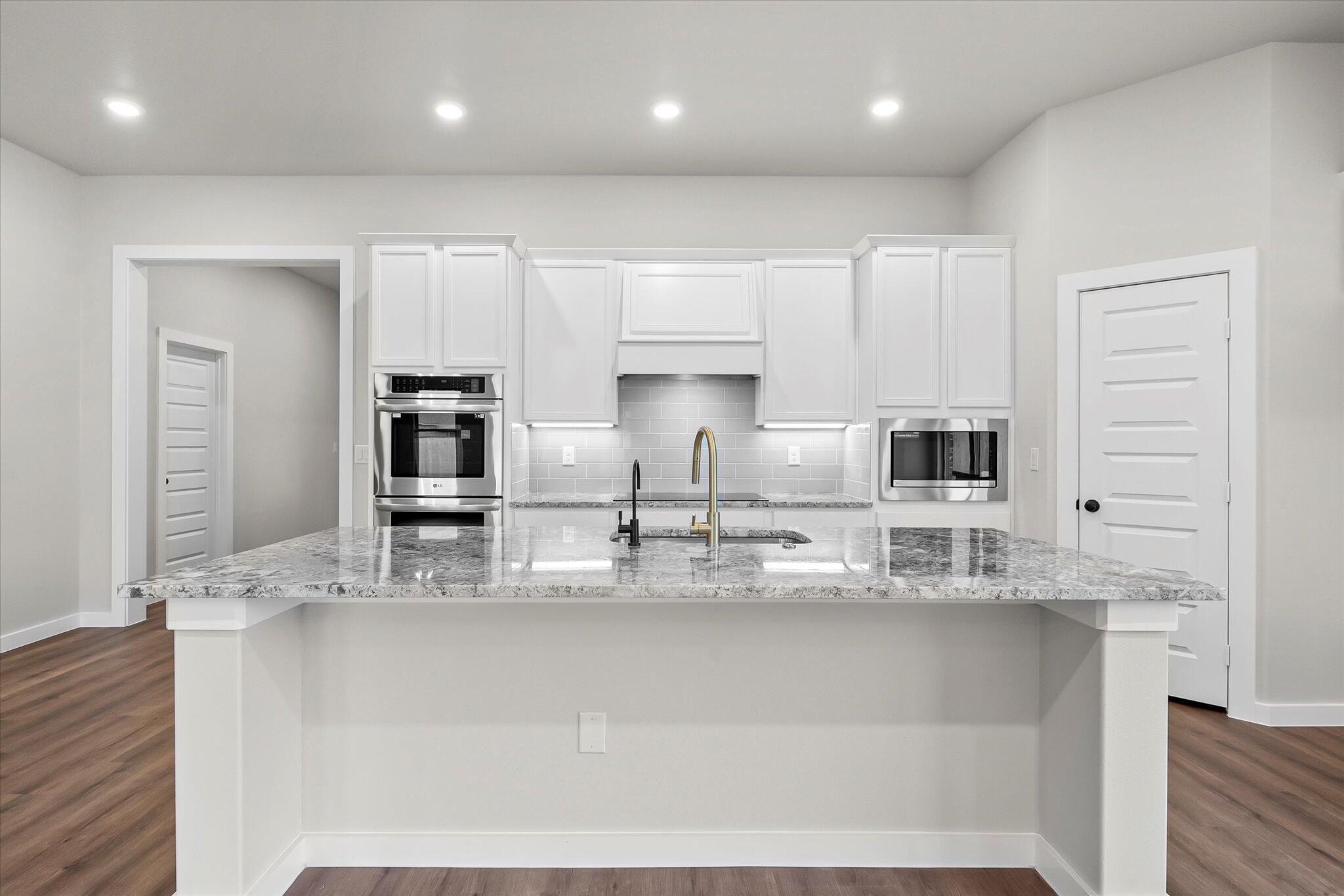 7436 30th Street Lubbock, TX 79407 - Photo 4 of 25 a kitchen with kitchen island granite countertop a sink and cabinets