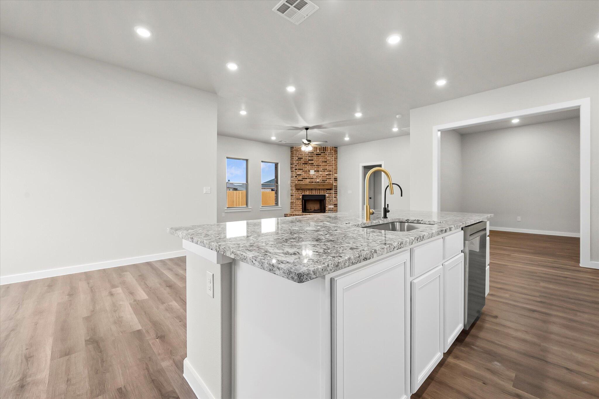 7436 30th Street Lubbock, TX 79407 - Photo 7 of 25 a kitchen with stainless steel appliances granite countertop a sink and a wooden floor