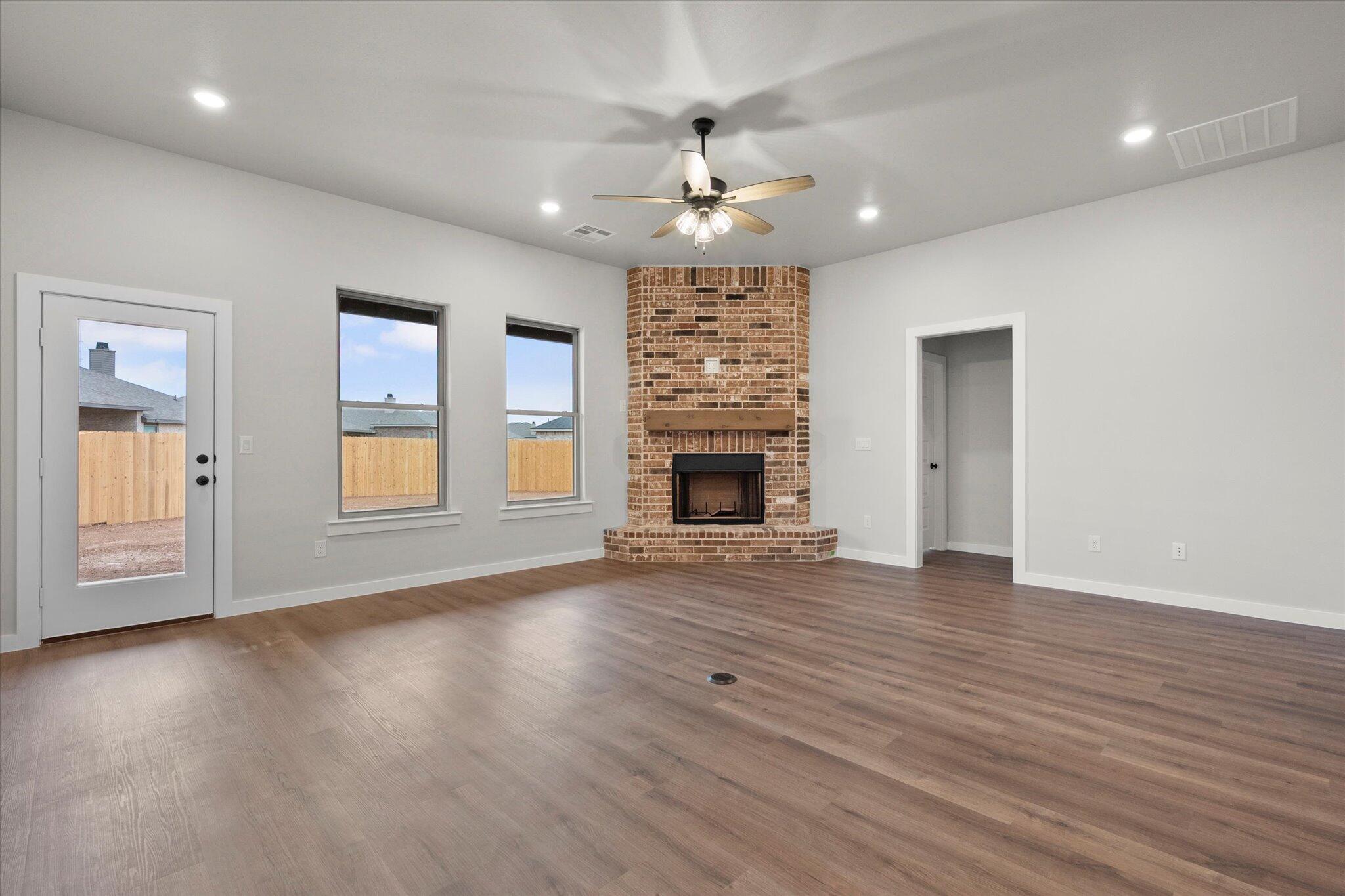 7436 30th Street Lubbock, TX 79407 - Photo 10 of 25 an empty room with wooden floor fireplace and window