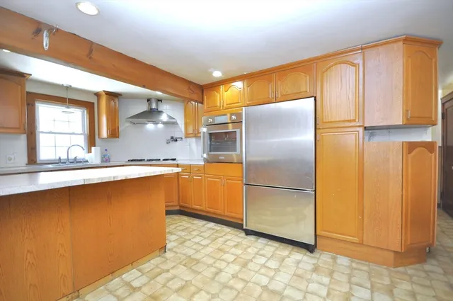 a kitchen with stainless steel appliances granite countertop a refrigerator and a sink