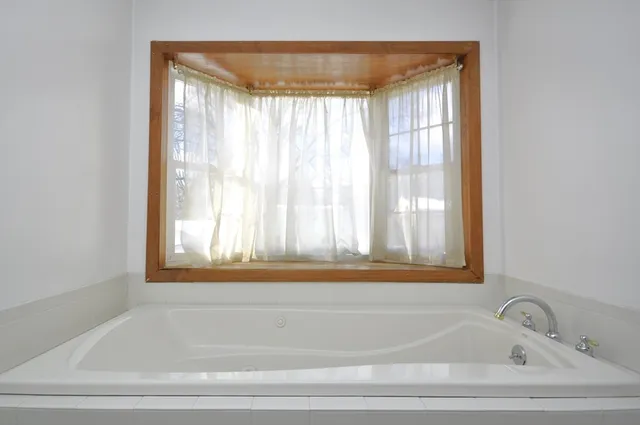 a bathroom with bathtub and window