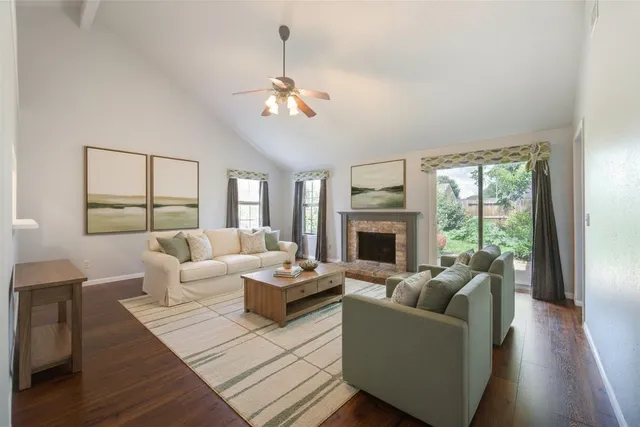 an empty room with wooden floor a fireplace and windows