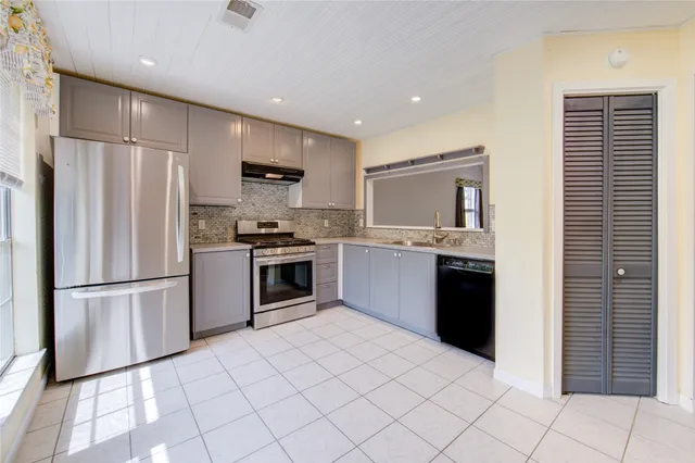 a kitchen with stainless steel appliances granite countertop a refrigerator sink and stove