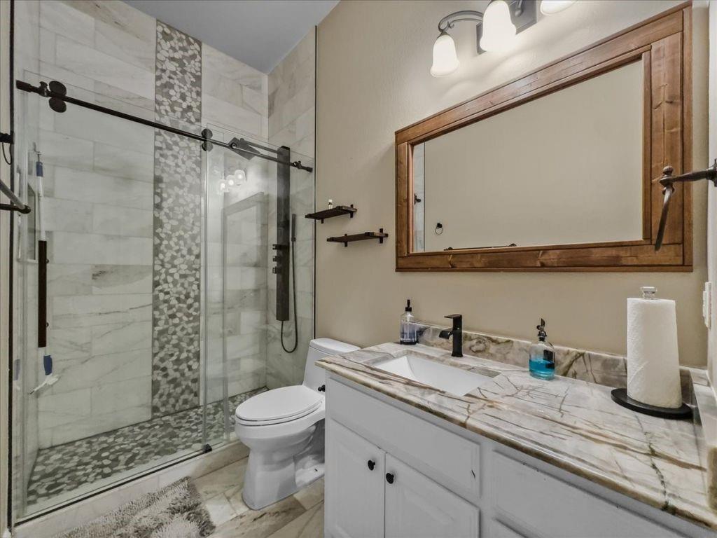 2832 Mona Vale Road Trophy Club, TX 76262 - Photo 23 of 37 a bathroom with a granite countertop sink toilet and shower
