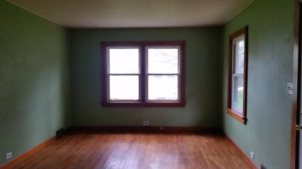 303 Marengo Road Harvard, IL 60033 - Photo 4 of 13 an empty room with wooden floor and windows
