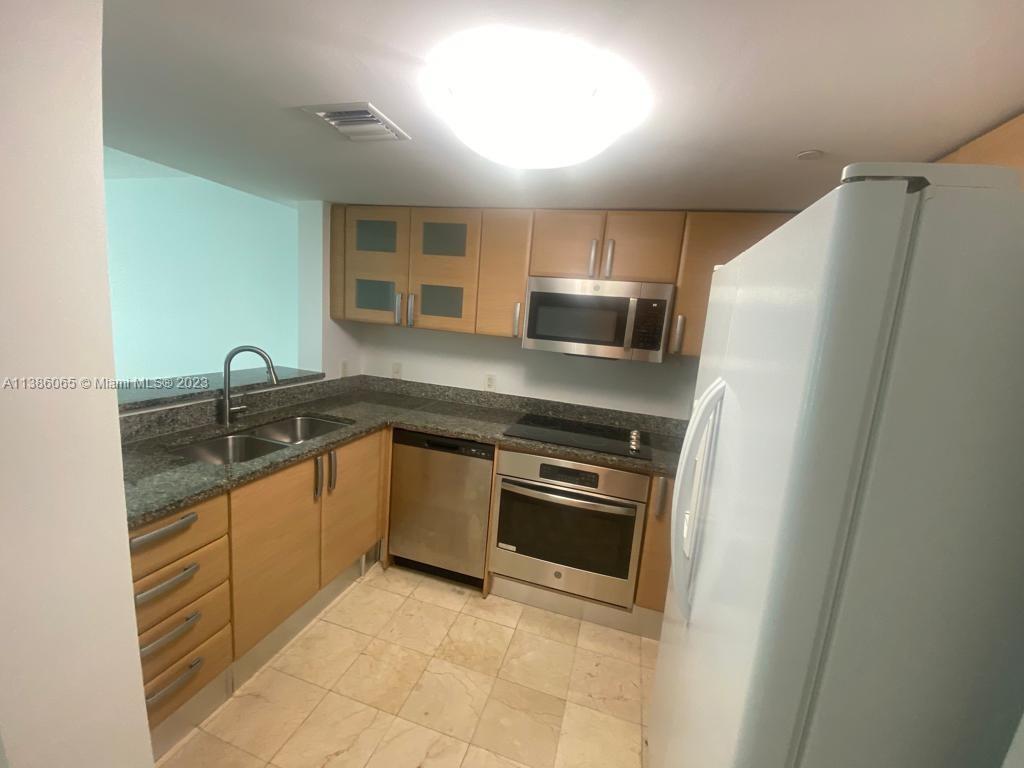 2101 Brickell Avenue, Unit 704 Miami, FL 33129 - Photo 4 of 32 a kitchen with stainless steel appliances granite countertop a sink and a stove top oven
