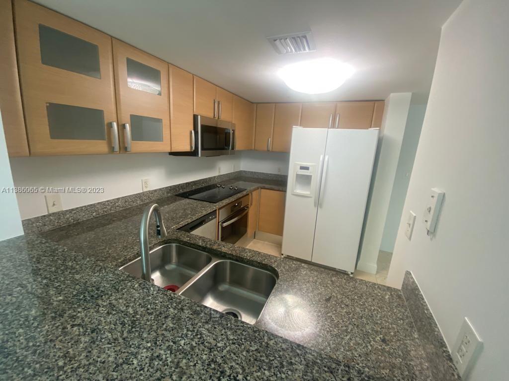 2101 Brickell Avenue, Unit 704 Miami, FL 33129 - Photo 5 of 32 a kitchen with a refrigerator a microwave and sink