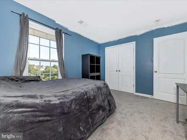 a bed sitting in a spacious bedroom next to a window