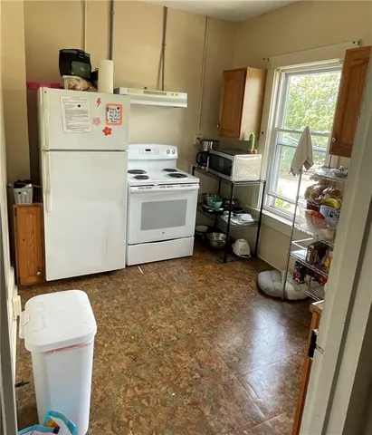 a kitchen that has a lot of cabinets a stove and a window