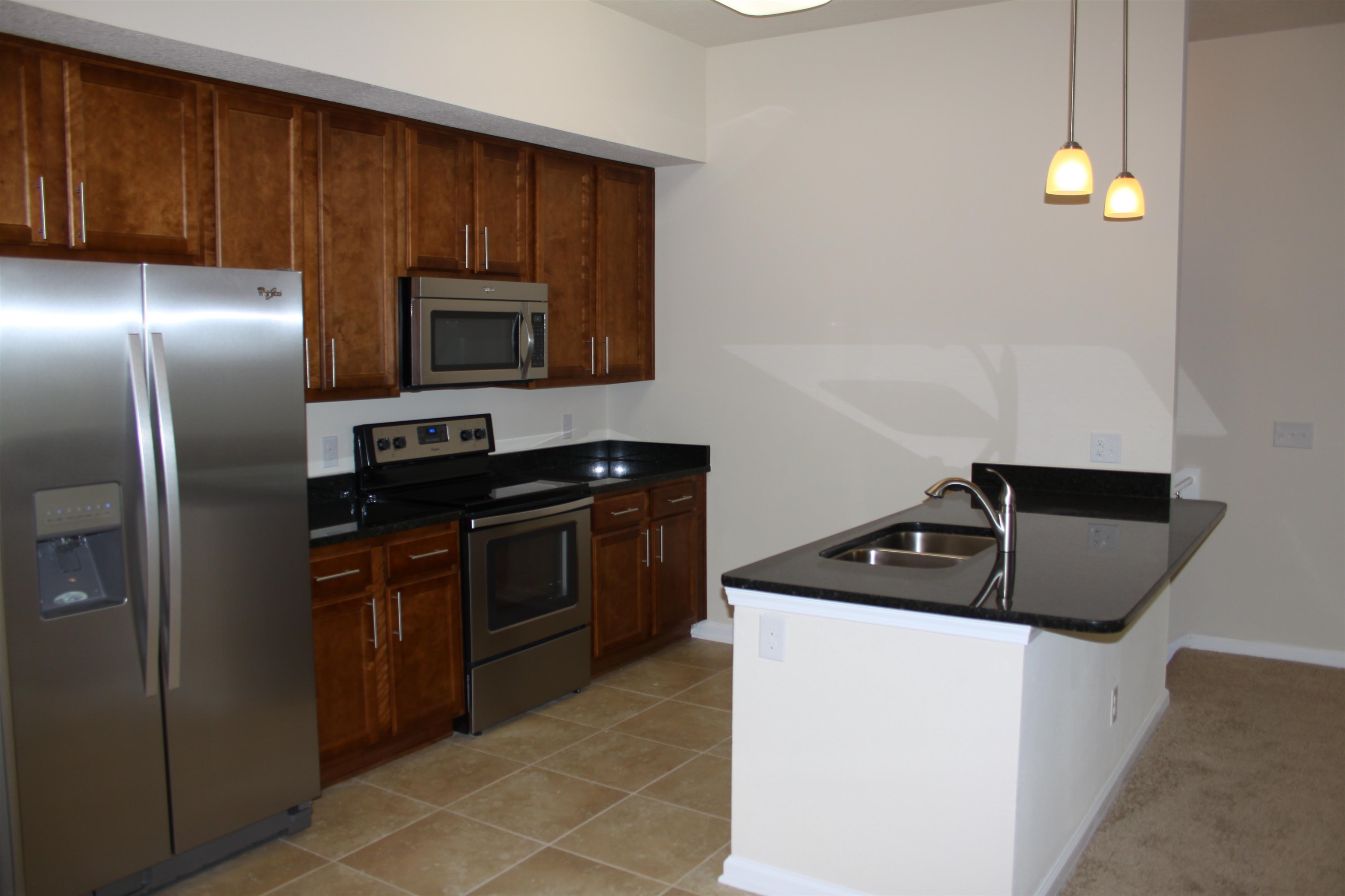 811 Golden Lake Loop St. Augustine, FL 32084 - Photo 2 of 20 a kitchen with granite countertop a refrigerator and a stove top oven