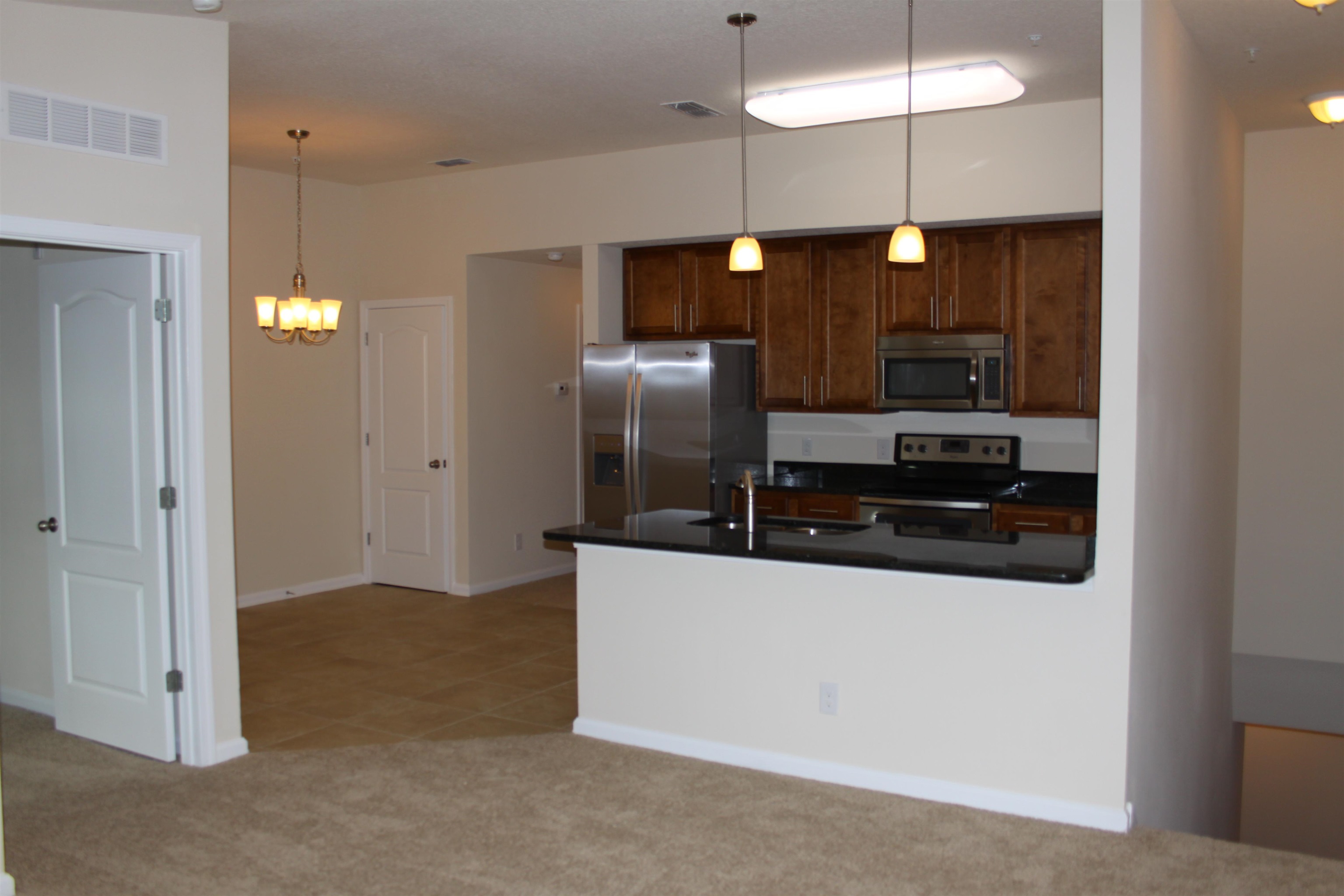 811 Golden Lake Loop St. Augustine, FL 32084 - Photo 5 of 20 a kitchen with stainless steel appliances granite countertop a refrigerator and a stove top oven