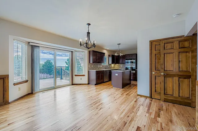 a view of kitchen with granite countertop stainless steel appliances and wooden floor