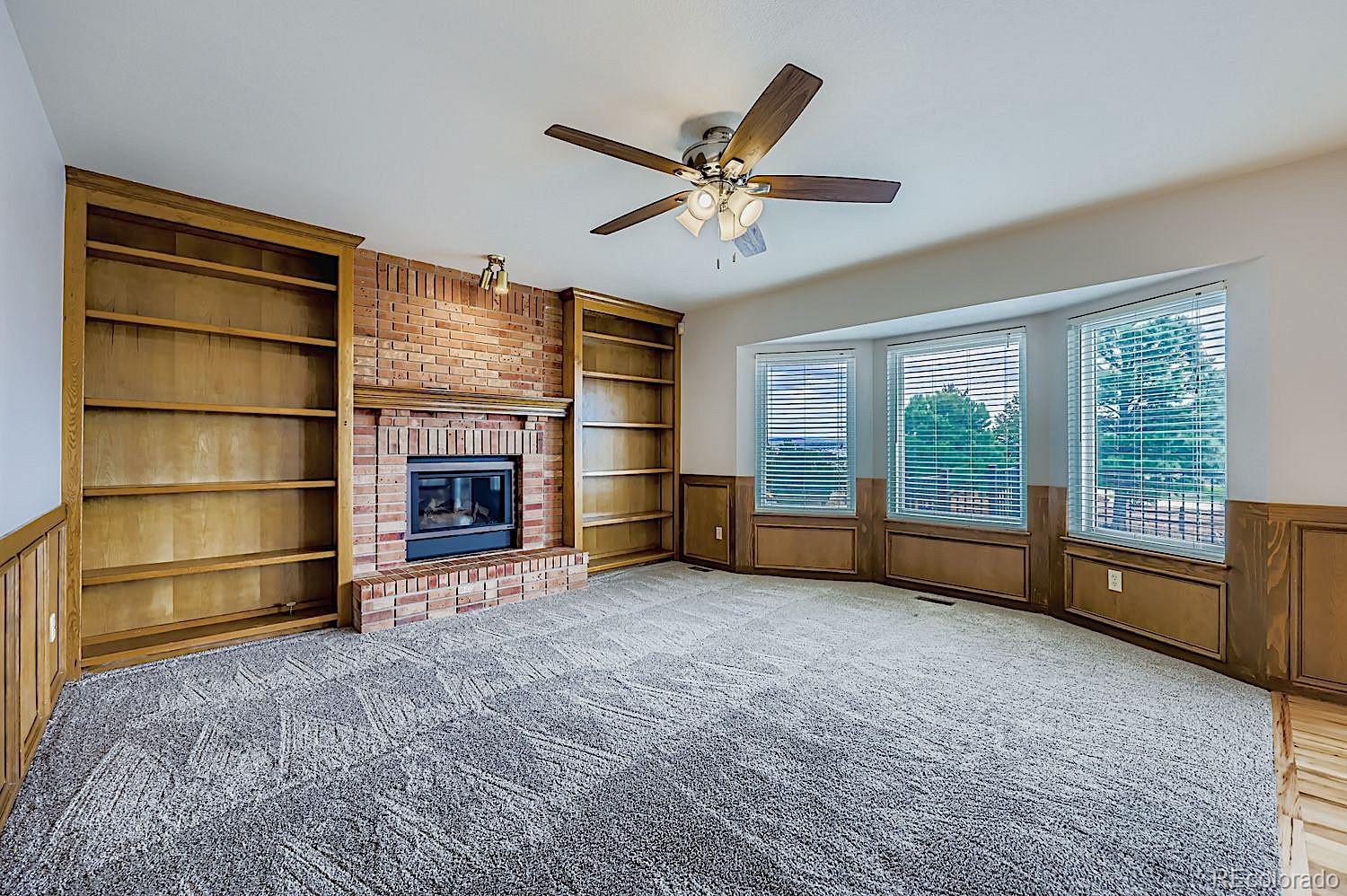 5825 Wilson Road Colorado Springs, CO 80919 - Photo 17 of 50 a view of an empty room with a fireplace and a window