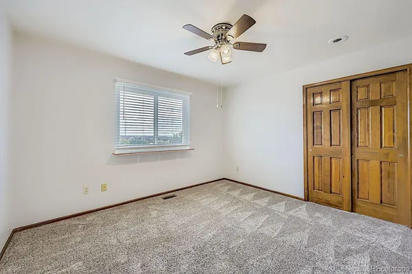 an empty room with a ceiling fan and a window