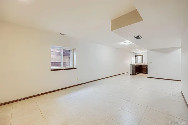 an empty room with fireplace and a window