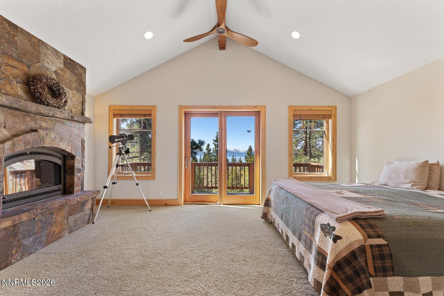 38 South Point Place Glenbrook, NV 89413 - Photo 14 of 24 a spacious bedroom with a bed a fireplace and a large window