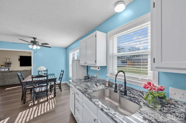 a kitchen with granite countertop a stove and a wooden floor