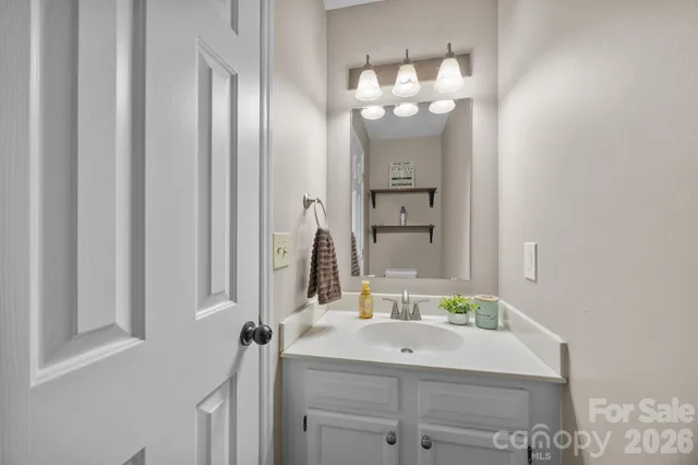 a bedroom with a bed a computer on the desk and a chair