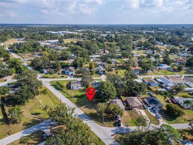an aerial view of residential houses with city and green space