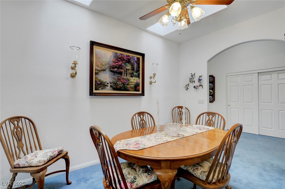 770 Fairway Drive Boulder City, NV 89005 - Photo 16 of 61 Dining space with carpet flooring, arched walkways, ceiling fan, and a skylight