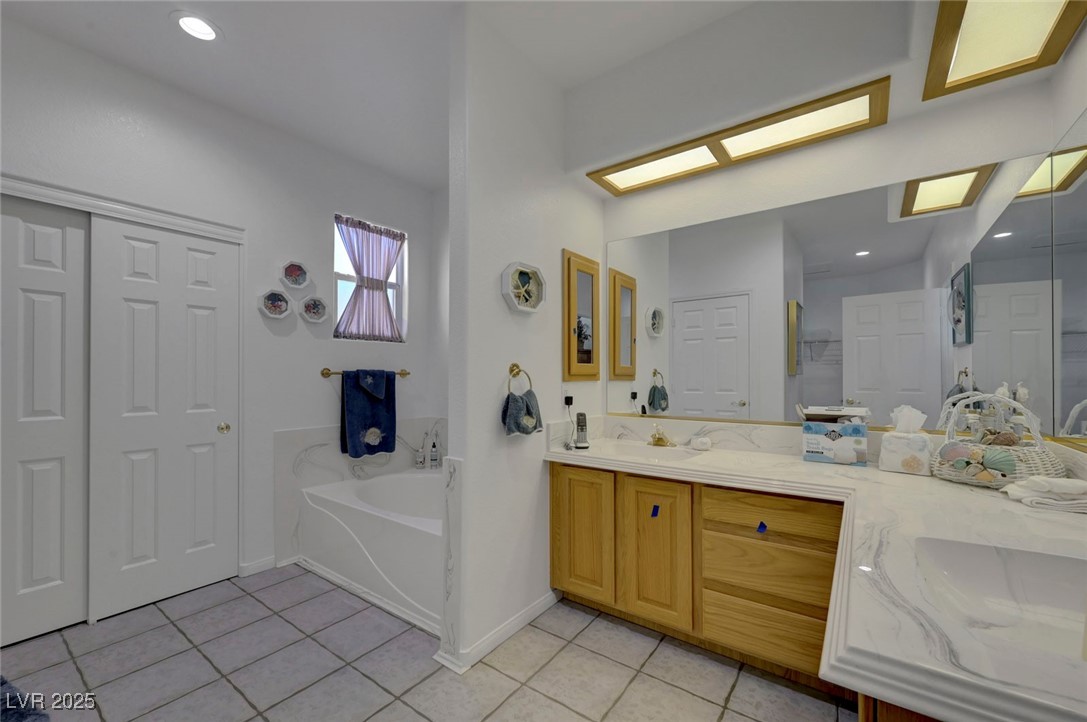 770 Fairway Drive Boulder City, NV 89005 - Photo 30 of 61 Bathroom featuring light tile patterned floors, double vanity, recessed lighting, and a garden tub
