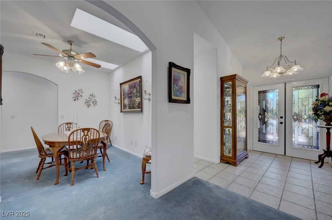 770 Fairway Drive Boulder City, NV 89005 - Photo 37 of 61 Dining area featuring arched walkways, light carpet, french doors, a chandelier, and lofted ceiling