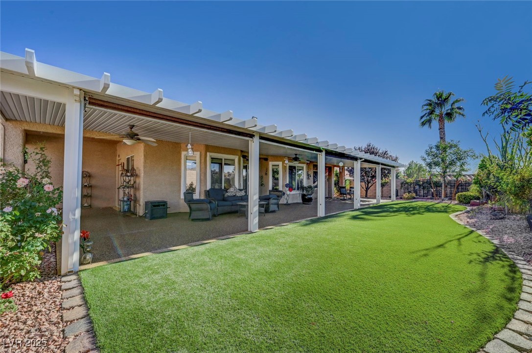 770 Fairway Drive Boulder City, NV 89005 - Photo 55 of 61 Rear view of property featuring ceiling fan, a fenced backyard, stucco siding, and an outdoor living space
