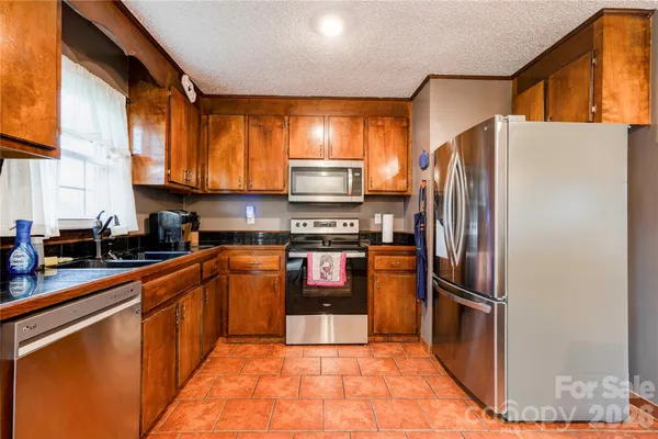 a kitchen with stainless steel appliances granite countertop a refrigerator stove and sink