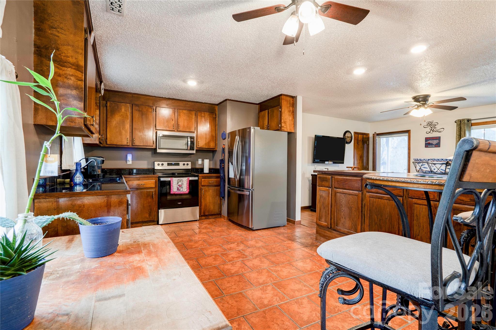 111 Hicks Road Grover, NC 28073 - Photo 12 of 35 a kitchen with stainless steel appliances kitchen island granite countertop a refrigerator a stove a sink a dining table and chairs with wooden floor