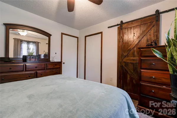 a bedroom with a bed and a mirror on the dresser