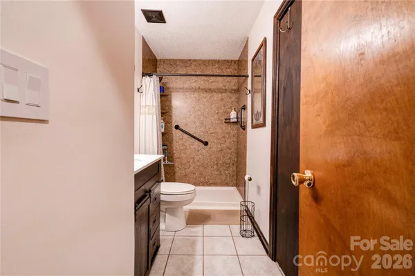 a bathroom with a granite countertop shower and a toilet